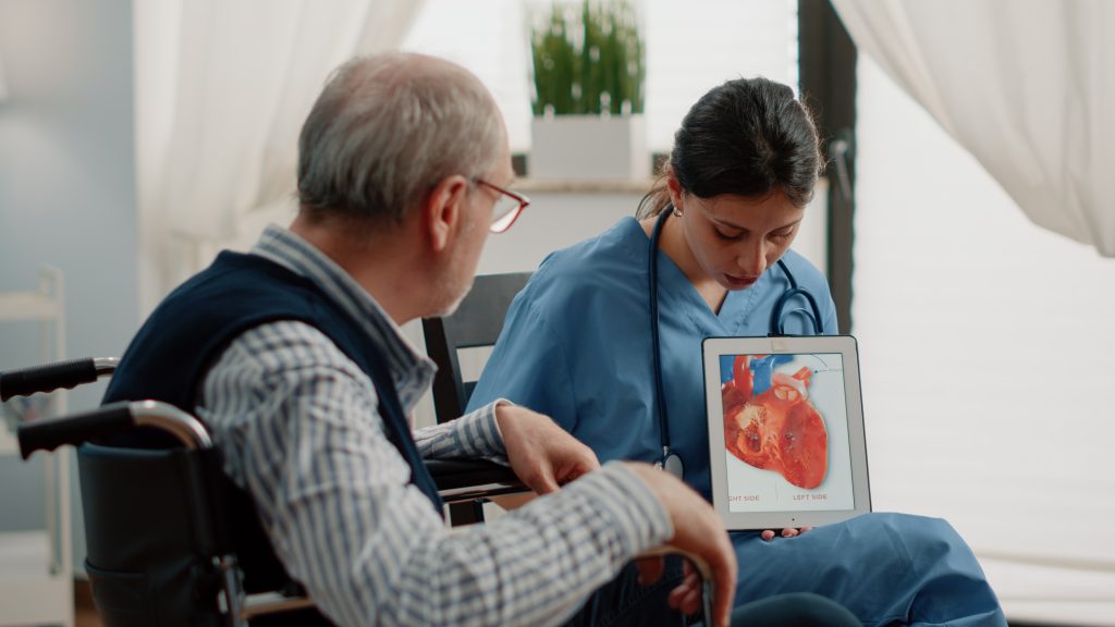 nurse holding tablet with heart figure for cardiology diagnosis